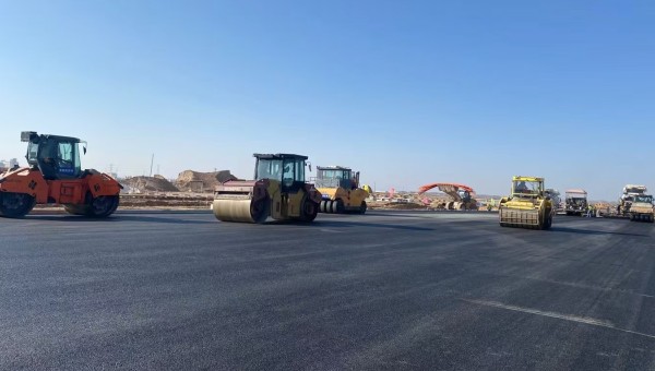 近日，在西部市政建設集團蘭州新區(qū)城市礦產與表面處理產業(yè)園區(qū)（二期）周邊基礎設施項目—園區(qū)西路南延段（緯五十路至緯二十八路）項目現場，隨著一輛輛運料車平穩(wěn)駛入，攤鋪機將滾燙的瀝青混合料均勻鋪開，標志著項